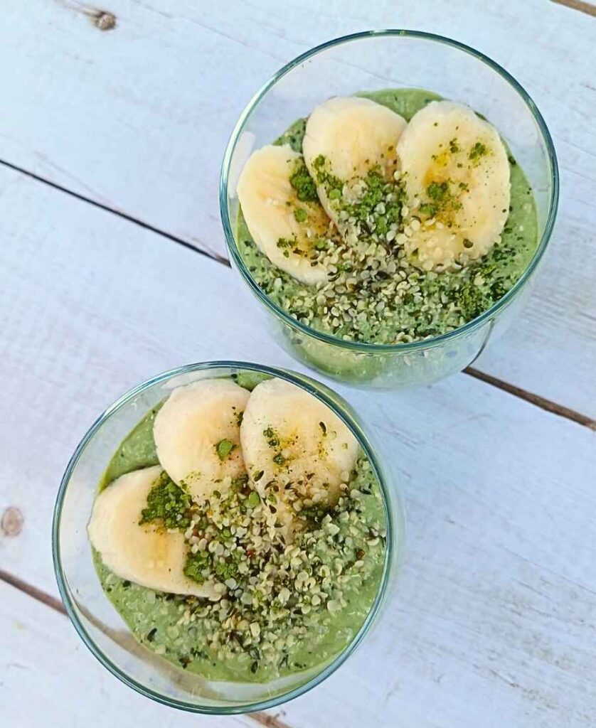 Two cups with matacha chia pudding with banana slices