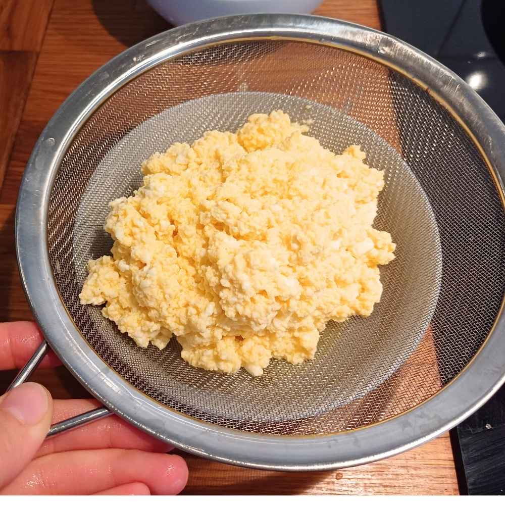 Draining cottage cheese and scrambled eggs in a strainer