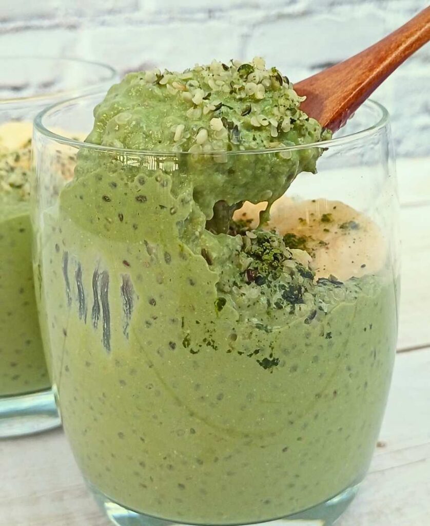 Spoon of matcha chia pudding from a glass cup