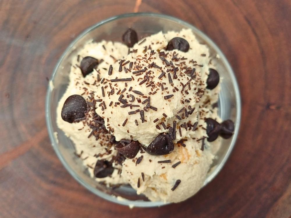 Top down view of a cottage cheese dessert served in a glass cup topped with chocolate chips