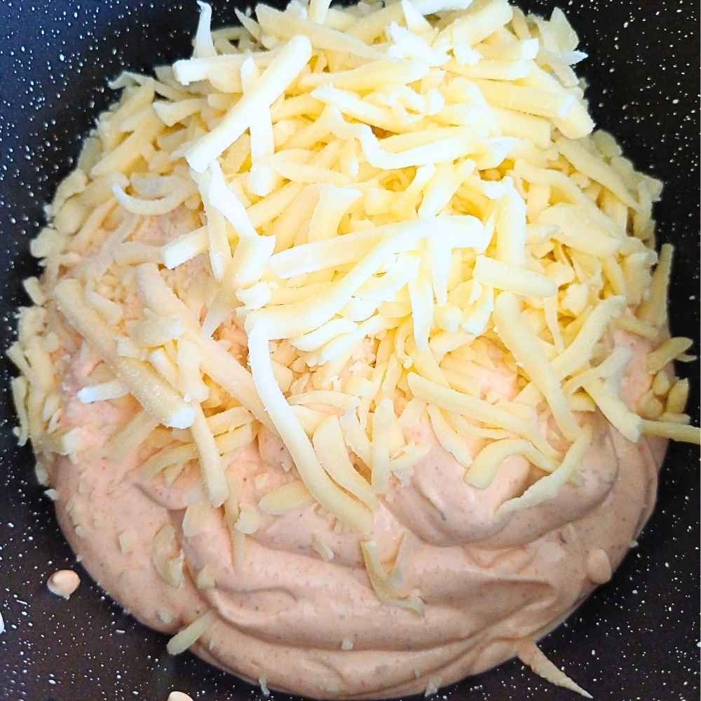 adding Mexican shredded cheese to blended cottage cheese for queso dip