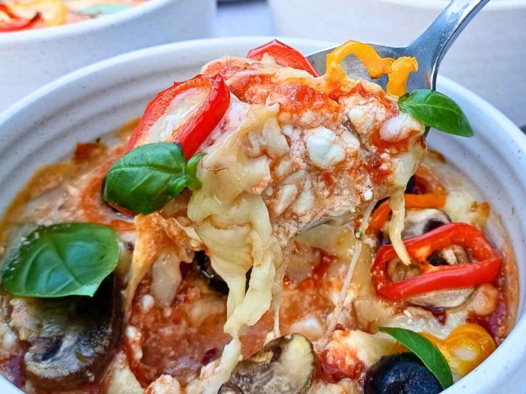 Cottage cheese pizza bowl close up with vegetables on top