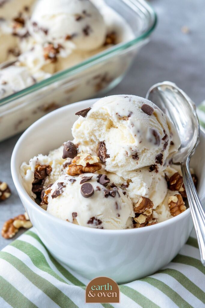 Ben and Jerry's Chunky Monkey Ninja Creami Protein Ice Cream version in a white bowl on a green stripy cloth.