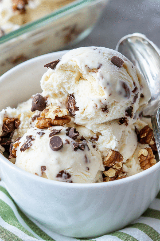 Ben and Jerry's Chunky Monkey Ninja Creami Protein Ice Cream version in a white bowl on a green stripy cloth.