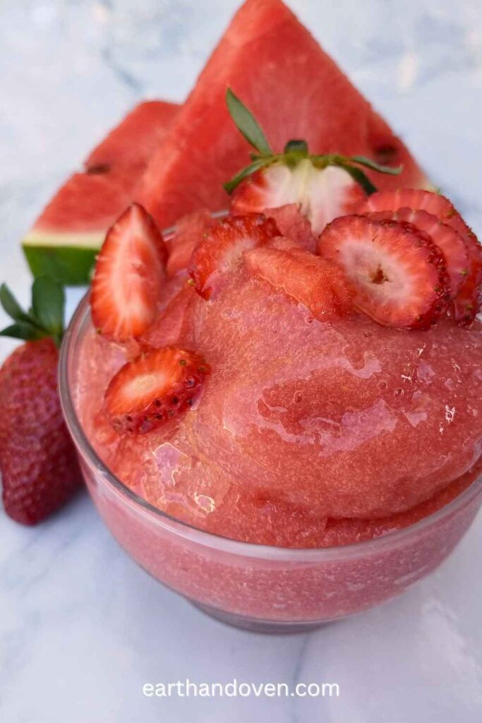 Watermelon sorbet made with Ninja creami ice cream machine at home with wedges on watermelon and sliced stawberries on the side and top