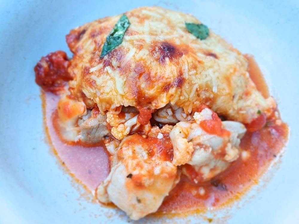 A serving of a low carb chicken casserole in a white bowl.