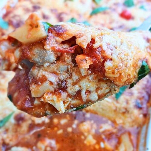 Juicy keto chicken parmesan casserole spooned out from a baking tray showing inside layers.