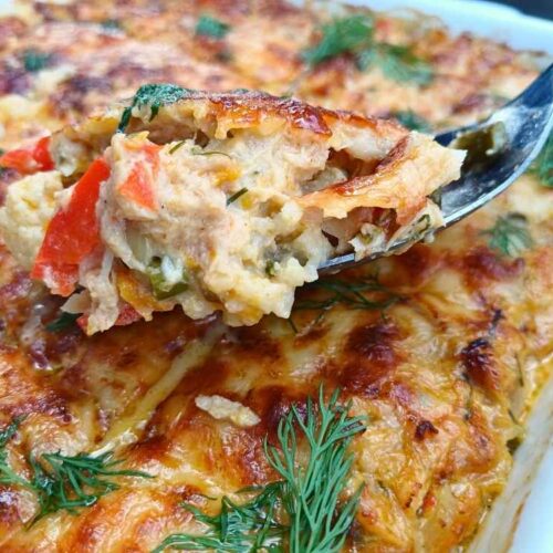 A spoon lifting a mouthful of keto tuna casserole from the baking tray to show the inside of the dish