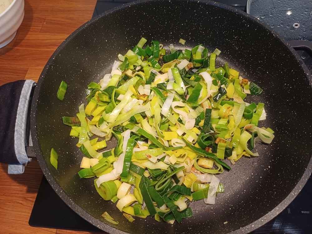 Leek sauteing on a frying pan with oil