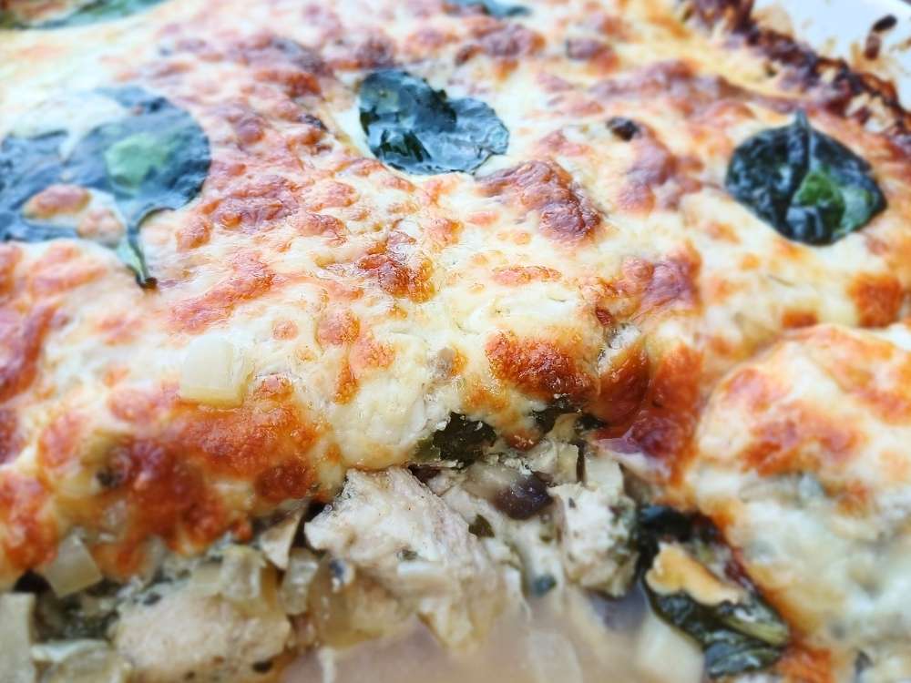 Inside of the creamy keto chicken mushroom casserole showing layers of chicken and vegetables inside.