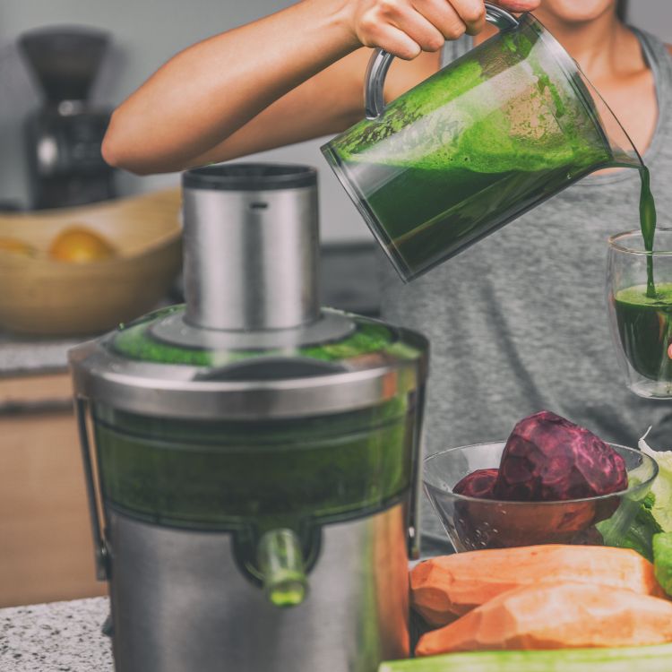 woman using centrifugal juicing machine to make green juice for weight loss