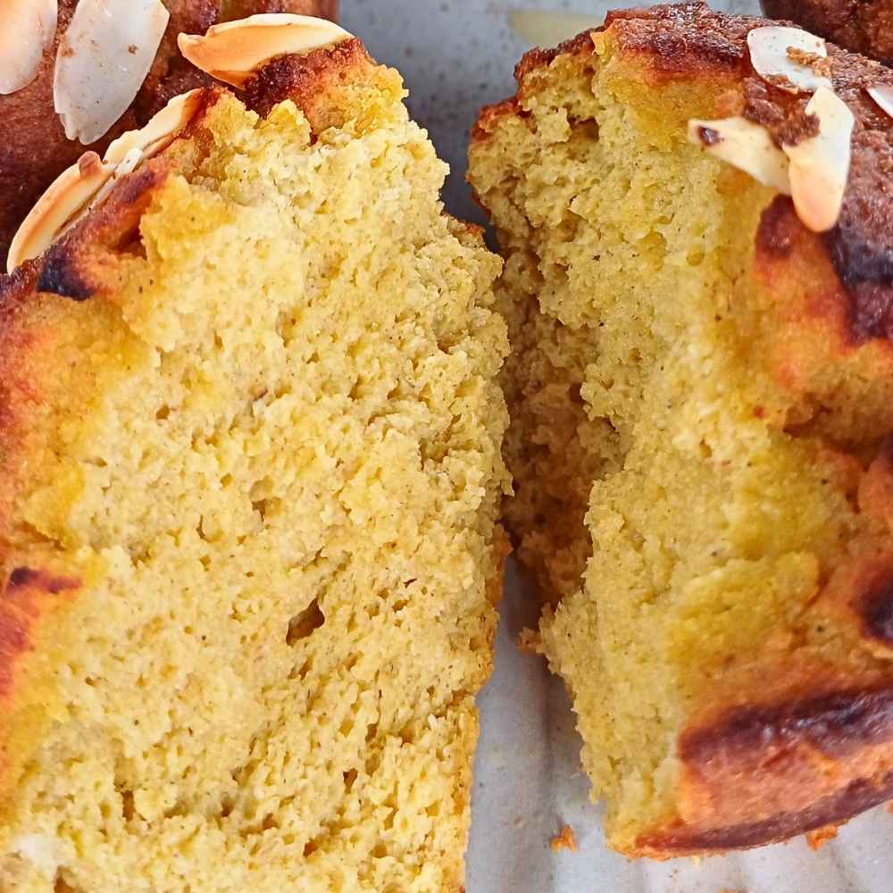 An open almond flour pumpkin muffins showing soft inside