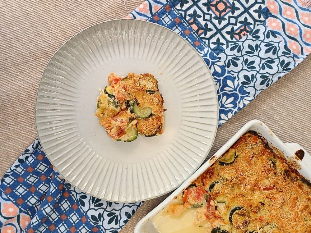 Top down view of a zucchini casserole portion on a plate.