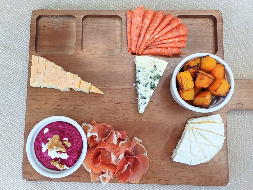 Steps showing hot to place cheese and ramekins with dips on a charcuterie board.