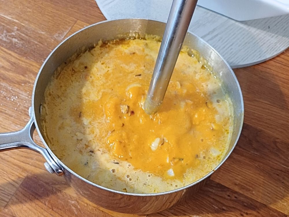 Blending the butternut squash soup with immersion blender.