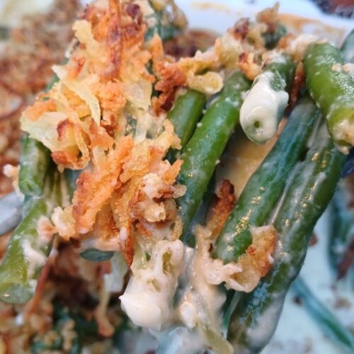 Cooked green bean casserole with crispy French fried onions.