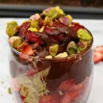 Glass cup filled with chocolate, strawberries, pistachios and kataifi