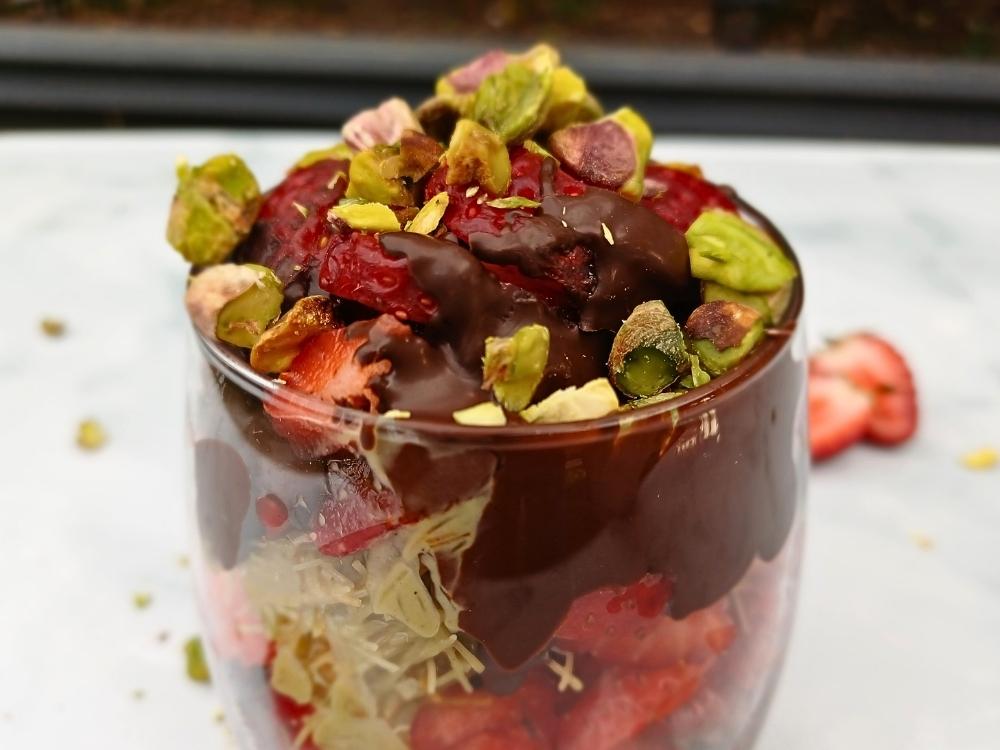 Glass cup filled with chocolate, strawberries, pistachios and kataifi