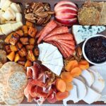 Top down view of a Thanksgiving style charcuterie board with turkey, pumpkins and seasonal grazing board items