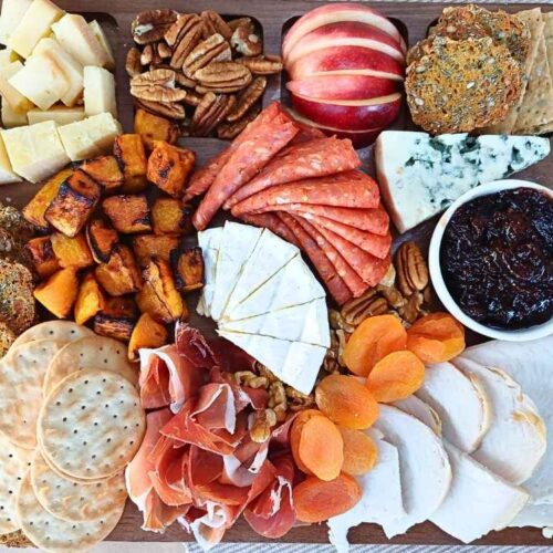 Top down view of a Thanksgiving style charcuterie board with turkey, pumpkins and seasonal grazing board items