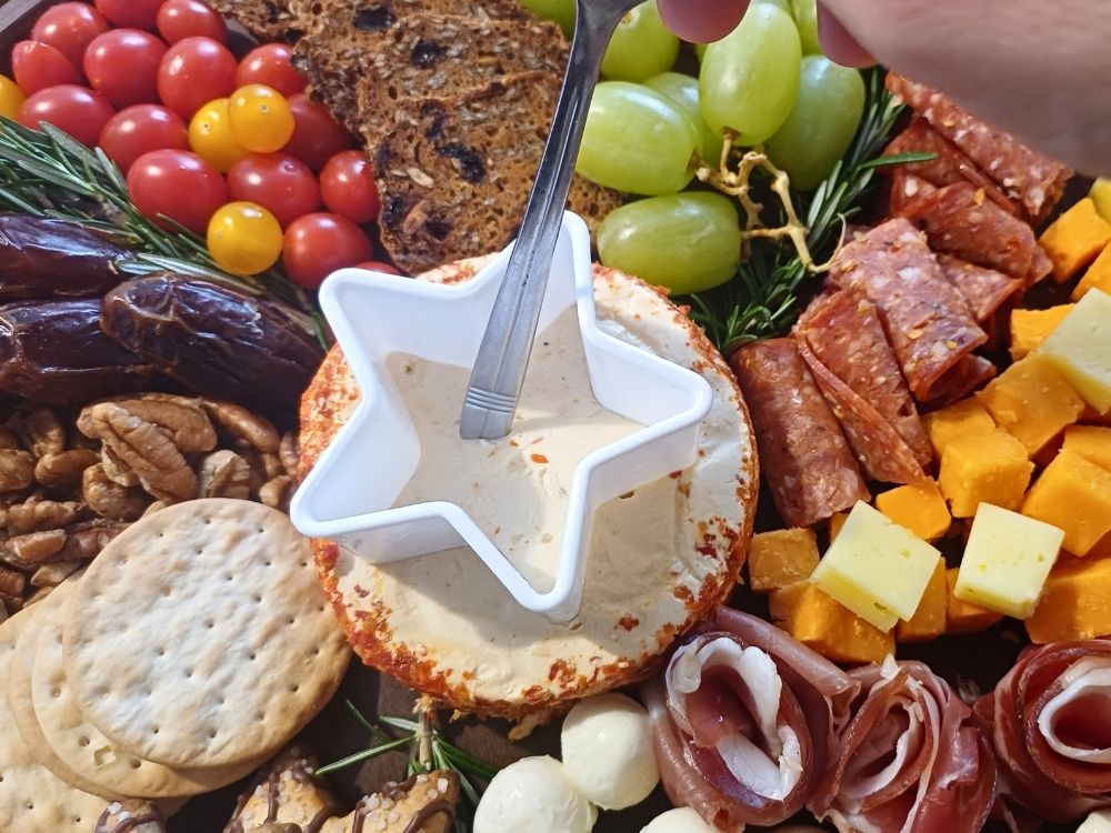 Carving out a star in the middle of a cheese wheel with a star shaped cookie cutter