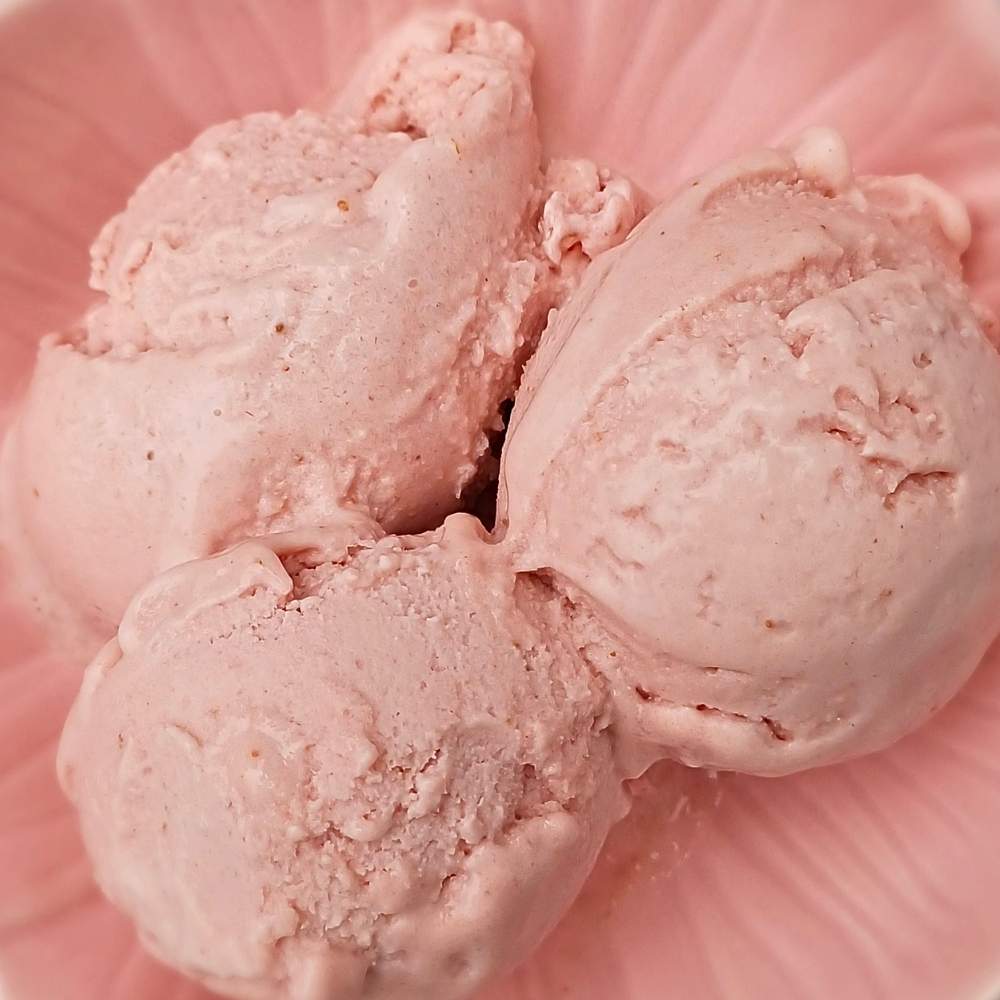 Scoops of strawberry ice cream in a pink bowl