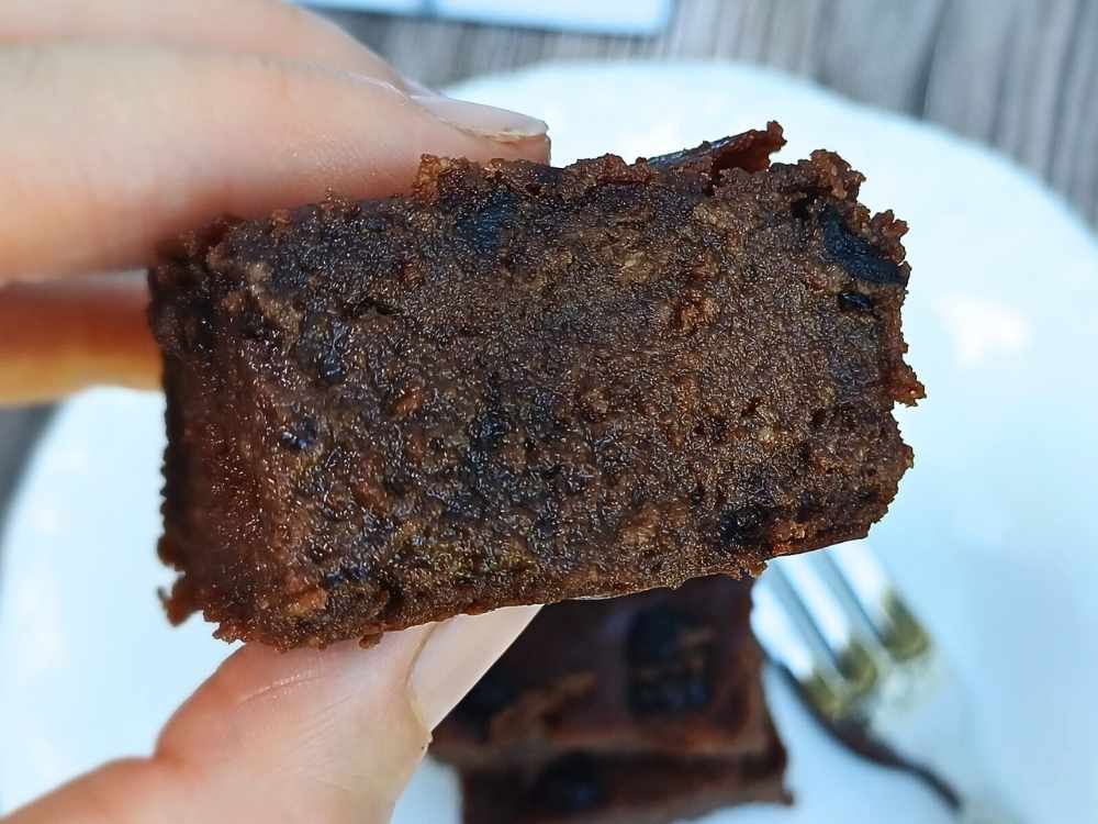 Fudgy chocolate brownie held up close with fingers