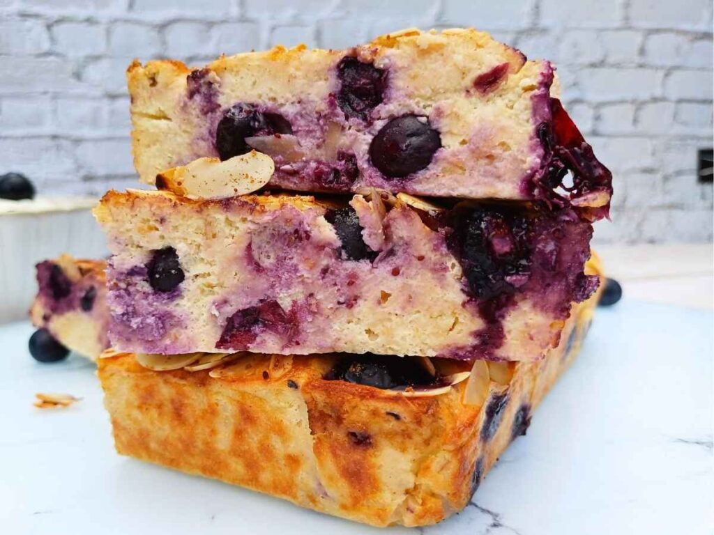 Stack of blueberry cottage cheese breakfast bake slices on a white marble board
