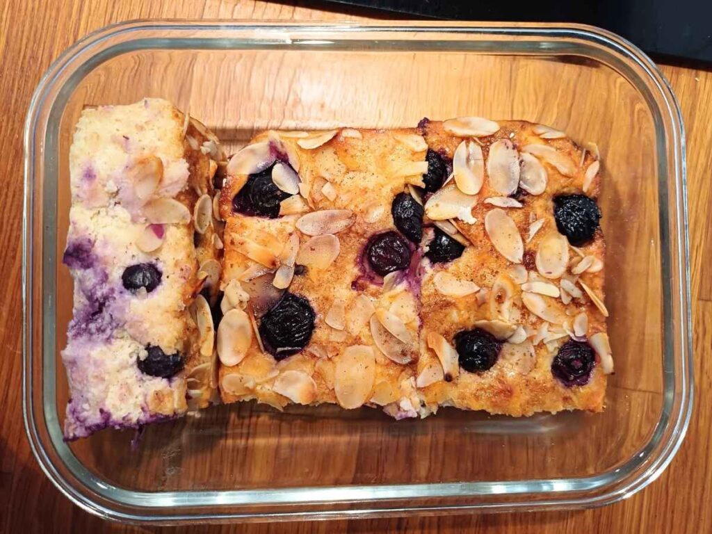 A glass container with blueberry cottage cheese breakfast bake inside