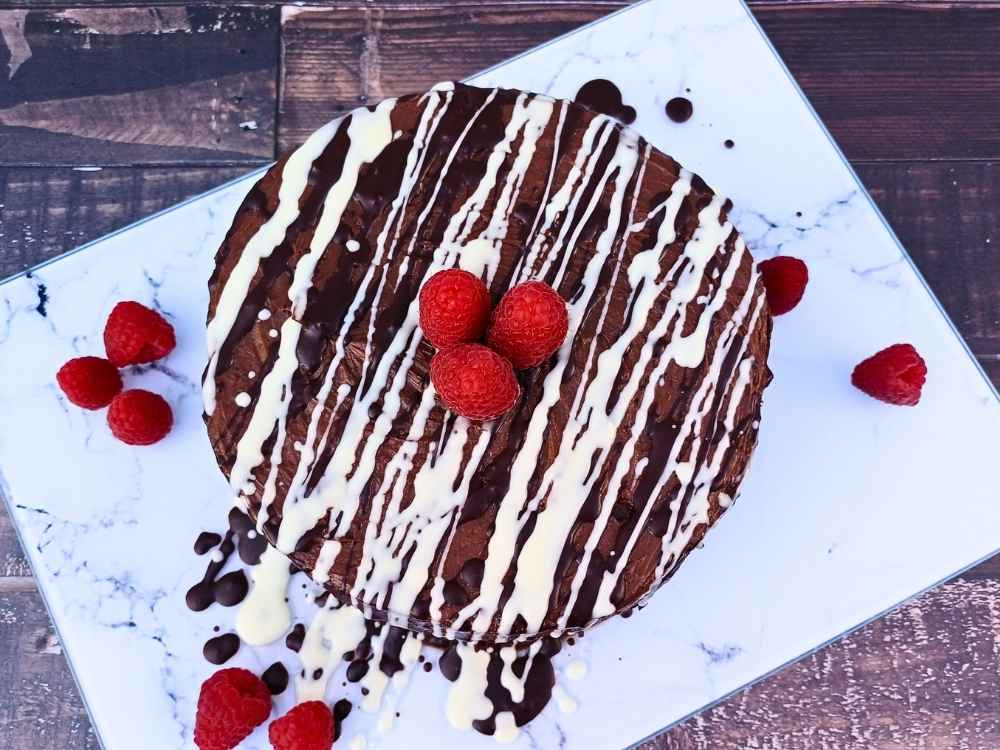 Top down view of a beautiful homemade almond flour chocolate cake with raspberries