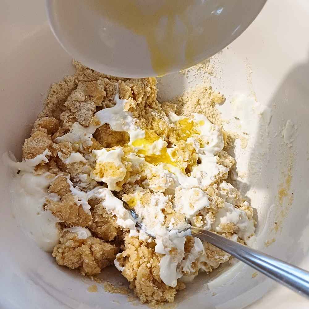 Adding yogurt and butter to the almond flour dough