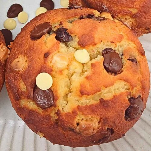 A homemade almond flour choc chip muffin with cracked top and golden edges