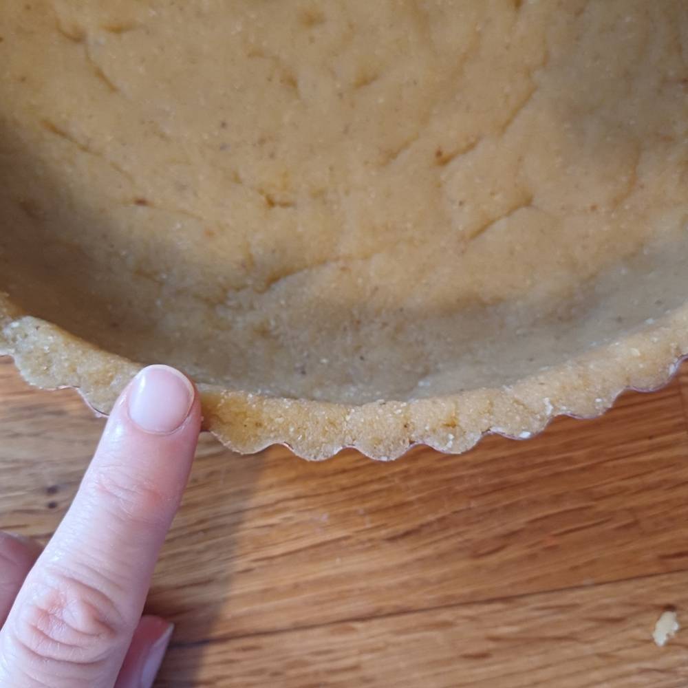 finger mesuring thickness of pie crust
