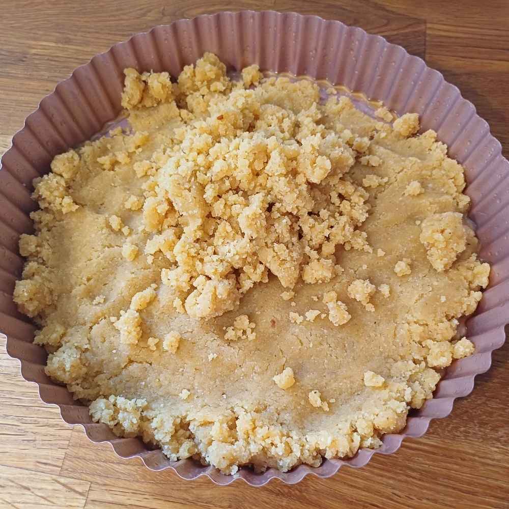 raw almond flour pie crust dough in a pie baking dish