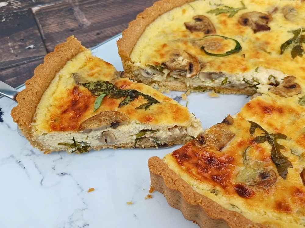 Quiche slice cut out to show inside of a creamy mush room filling inside an almond flour pie crust