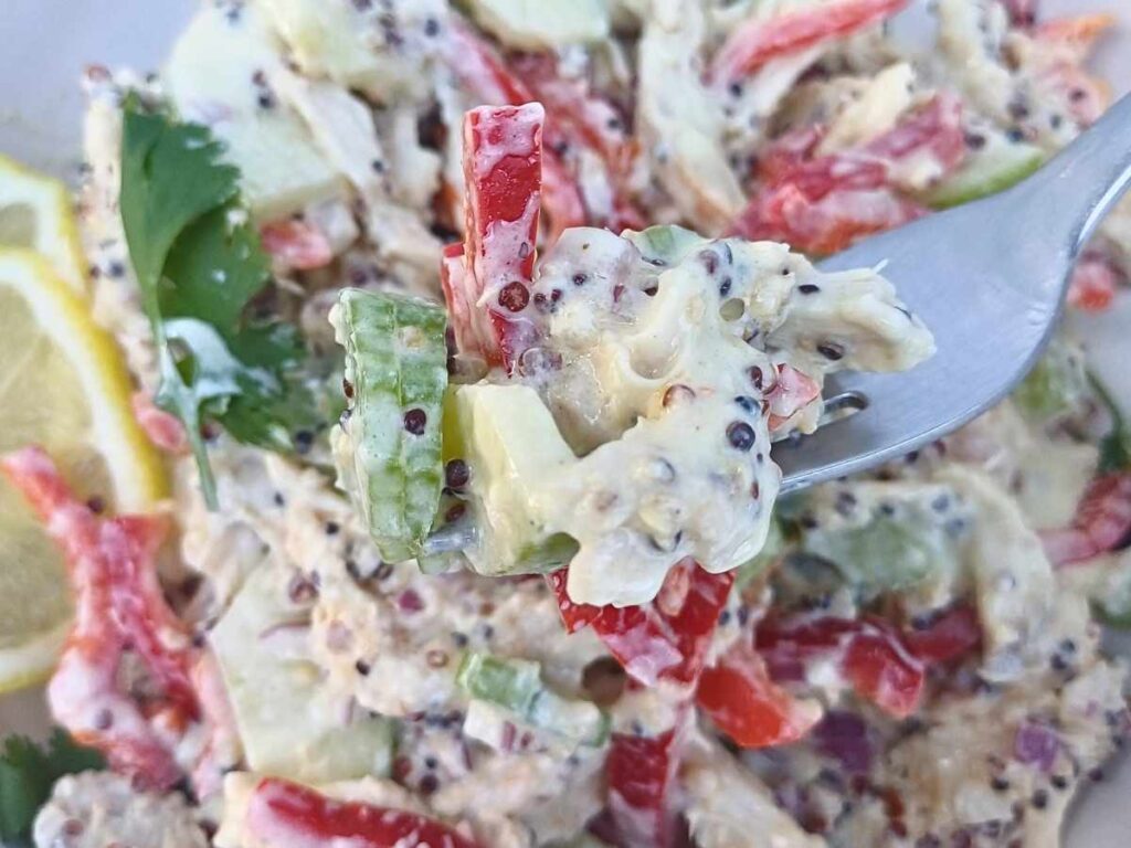 healthy chicken and vegetable salad in creamy dressing on a fork