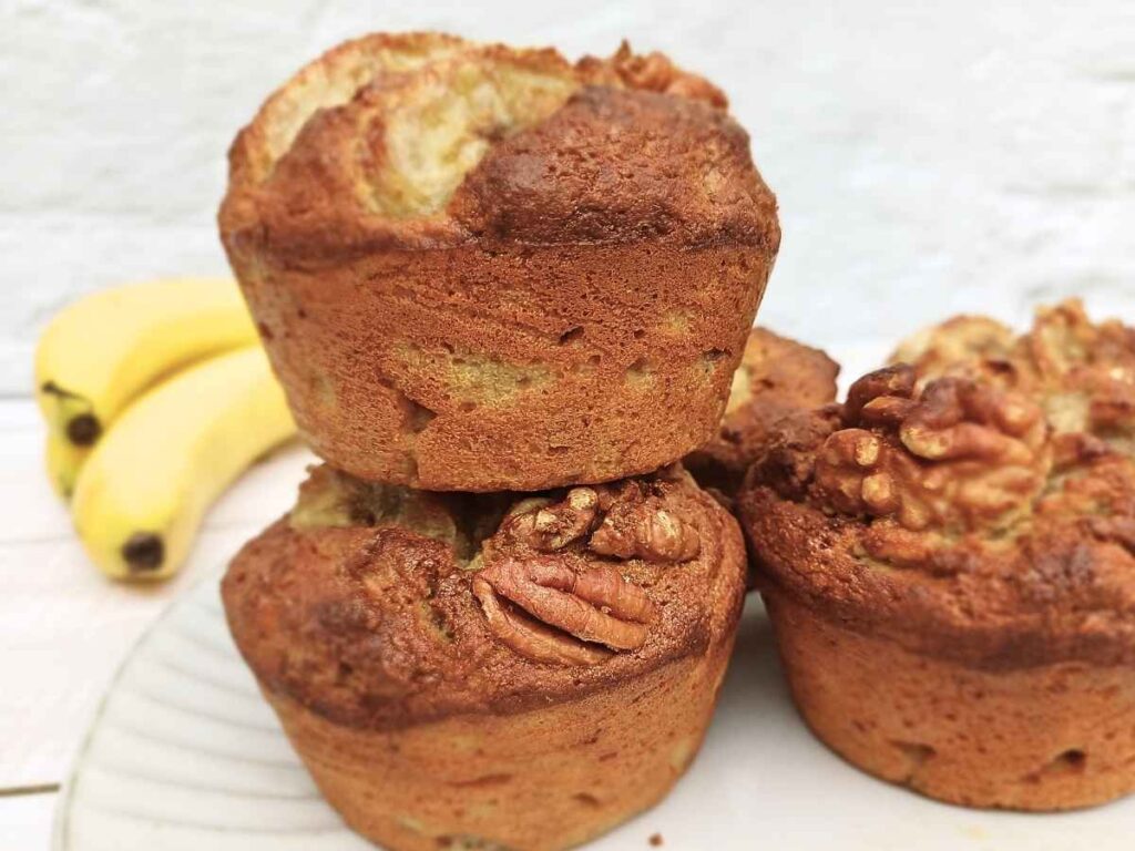 Almond flour banana muffins with walnuts stacked on top of each other