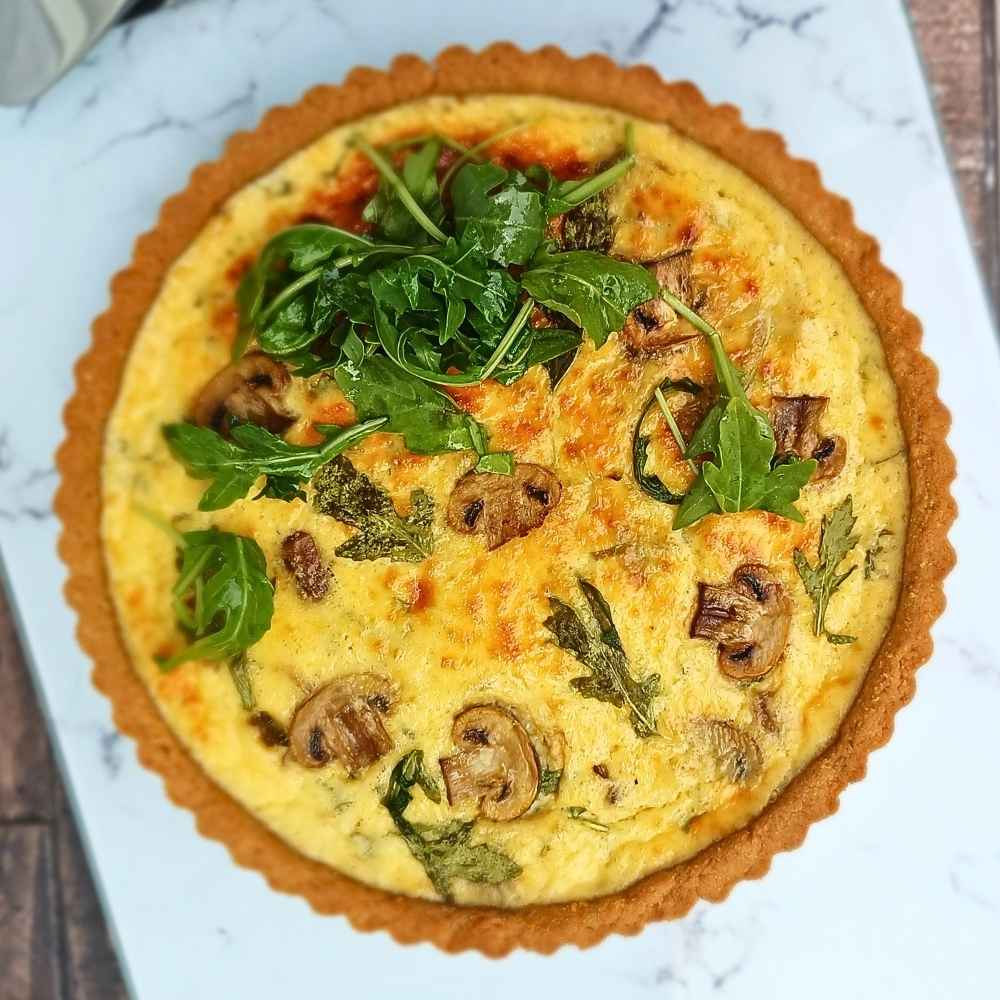 A cottage cheese quiche with almond flour crust, mushrooms and arugula photo from the top