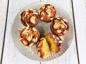 A plate of almond flour pumpkin muffins with one broken to see inside