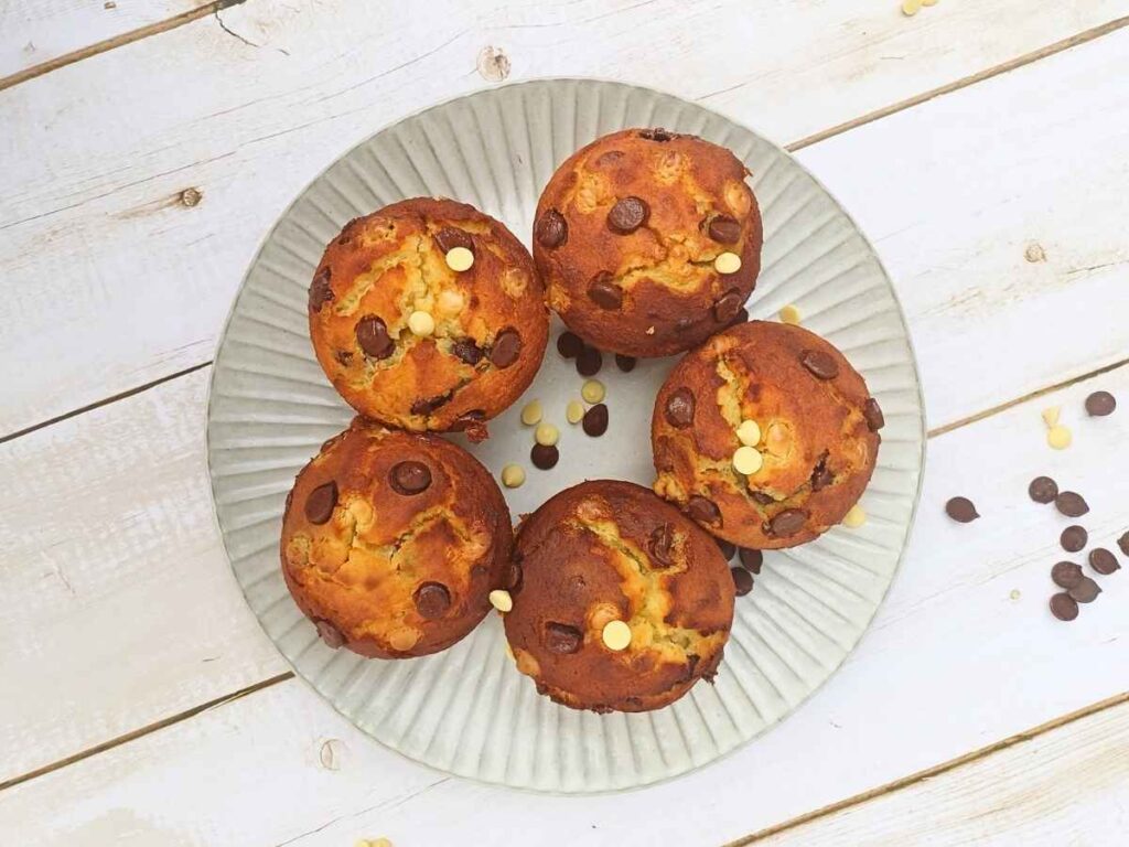 Five almond flour chocolate chip muffins on a white plate