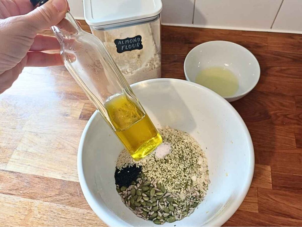 Almond flrou and seeds in a bowl and olive oil bottle