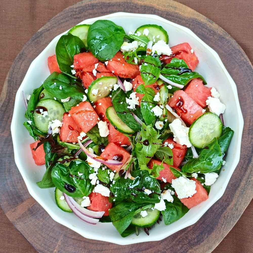 A bowl of watemelon feta salad with spring mix