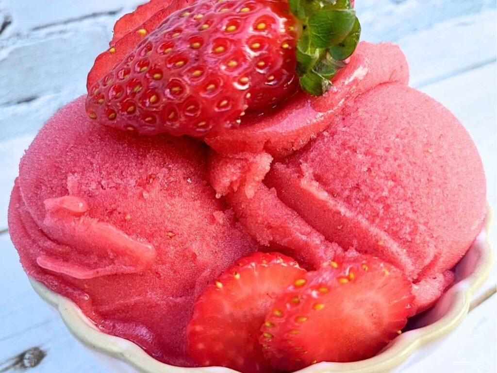 Strawberry sorbet Ninja Creami recipe topped with fresh strawberries in a serving bowl