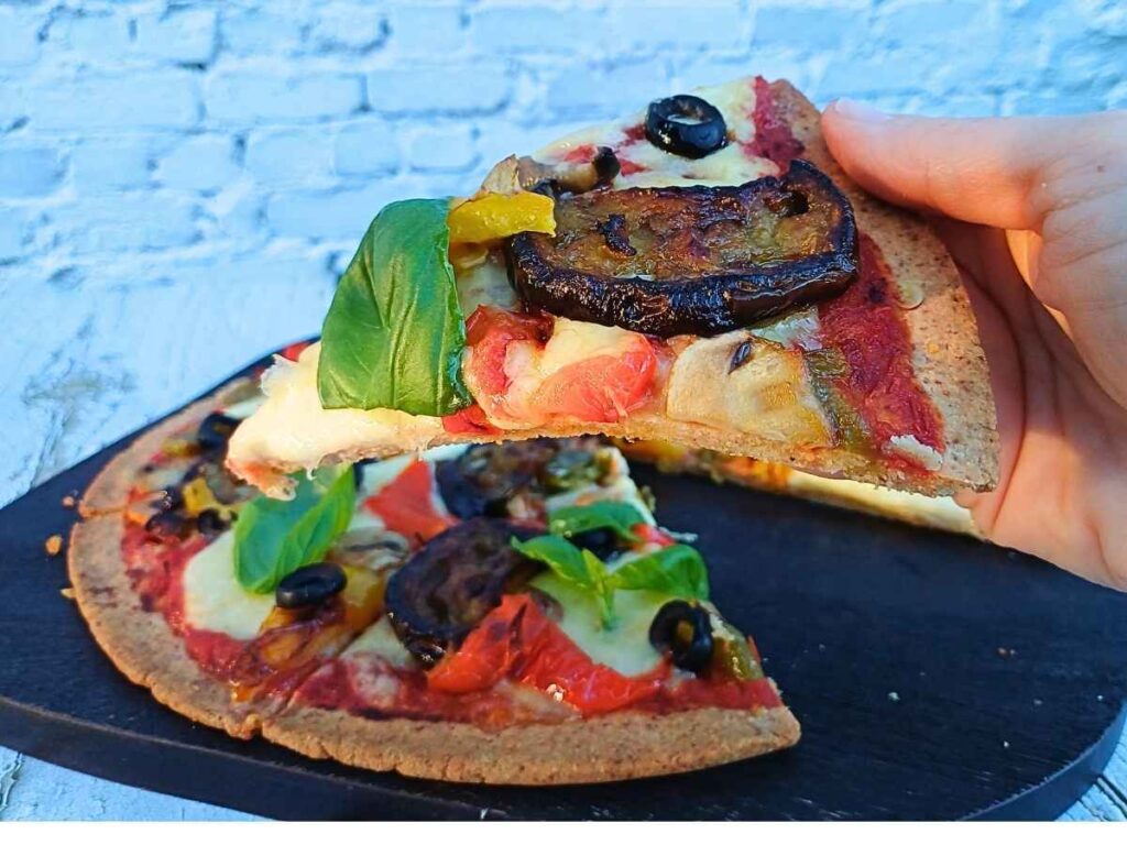 Vegetarian almond flour pizza slice with fresh basil