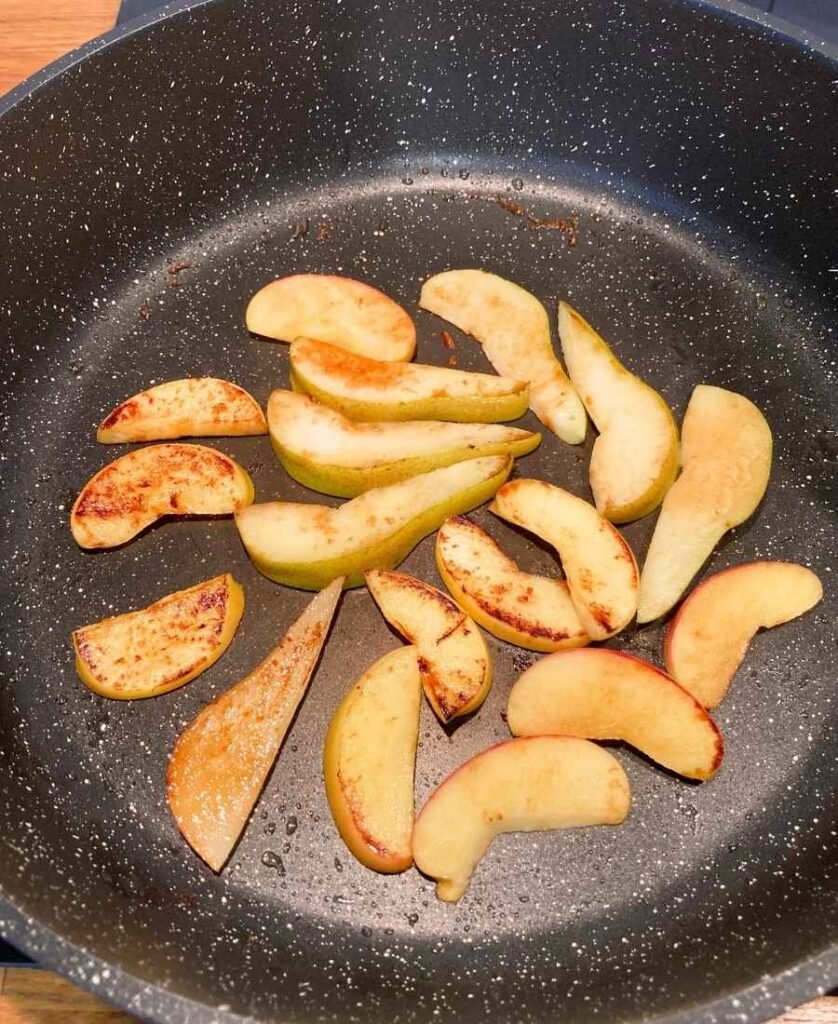 Caramelizing apples and pears on a stovetop in a pan