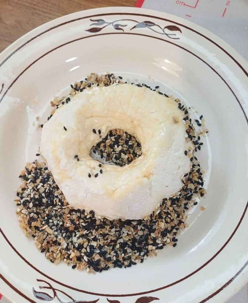 Dipping bagels into seasoning